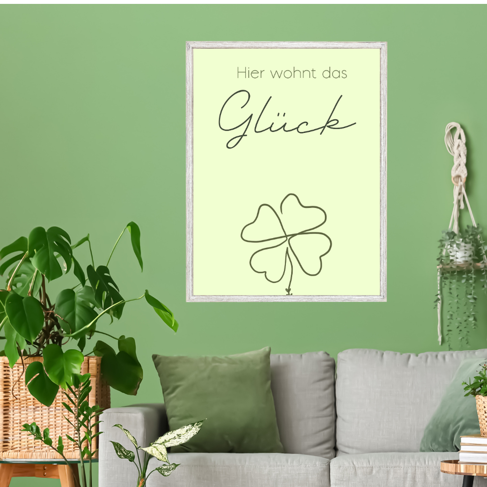 Wandbild „Hier wohnt das Glück“ mit Kleeblatt im grünen Wohnzimmer